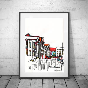 Puede incluir: Impresión artística enmarcada que presenta un dibujo lineal colorido de una escena callejera junto al agua. Los edificios con acentos rojos, amarillos y azules se representan en un estilo minimalista. La obra de arte está sobre un fondo blanco.