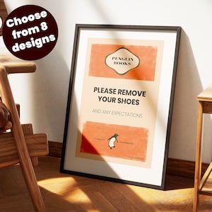 Może przedstawiać: Oprawiony wydruk z czarną obwódką. Wydruk zawiera pogrubiony tekst "PLEASE REMOVE YOUR SHOES AND ANY EXPECTATIONS". Logo Penguin Books znajduje się na górze, a ilustracja pingwina na dole. Okrągła grafika mówi "Wybierz spośród 8 wzorów".