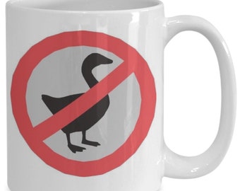 May include: White ceramic coffee mug with a red circle and diagonal line through a black silhouette of a goose. The text "No Goose" is not visible in the image.
