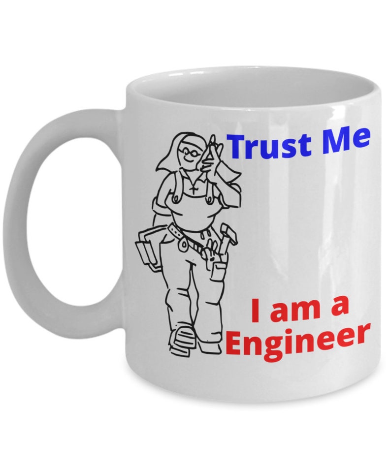 May include: White ceramic mug with a black and white cartoon illustration of a person wearing a tool belt and holding a hammer. The text "Trust Me I am a Engineer" is printed in blue and red on the mug.