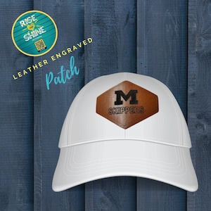 May include: White baseball cap with a brown leather patch that says "M Skippers" in black lettering.