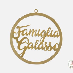 May include: A gold-colored metal circle ornament with the words "Famiglia Galasso" written in a cursive font.
