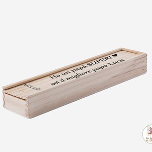 Può includere: Una scatola di legno con un coperchio scorrevole. La scatola è incisa con il testo "Ho un papà SUPER! sei il migliore papà Luca" e un simbolo di cuore.