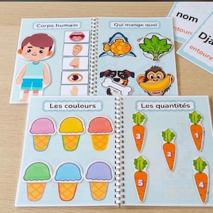 Peut inclure: Un livre d'activités à reliure spirale éducatif présentant des pages interactives sur le corps humain, l'alimentation animale, les couleurs et les quantités. Il contient des illustrations colorées d'une personne, d'animaux, de glaces et de carottes numérotées.