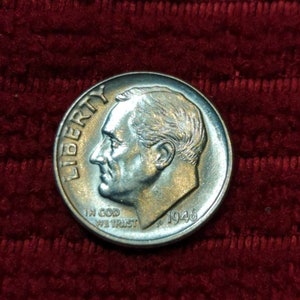 May include: A silver US dime coin with the year 1946 and the words "Liberty" and "In God We Trust" inscribed on it.