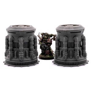 May include: Two gray, detailed, plastic, miniature, industrial, sci-fi,  cylinder structures with pipes and vents. The structures are about 3 inches tall.