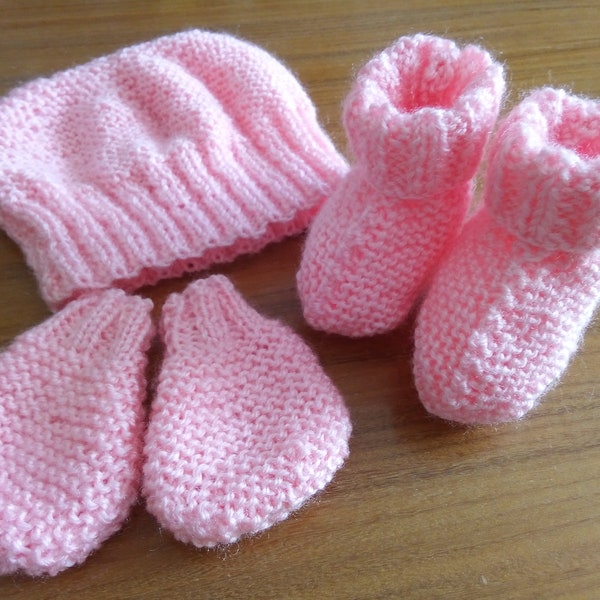 Kit naissance rose composé d'une paire de chaussons , d'une paire de moufles et d'un bonnet .