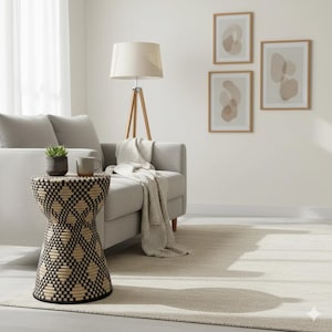 Pode incluir: Uma sala de estar com um sofá cinza claro, uma mesa lateral tecida com um padrão geométrico e um candeeiro de pé tripé de madeira com uma abajur bege. Obras de arte abstratas adornam a parede. Um tapete e um cobertor completam o ambiente.