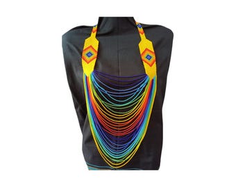 May include: A vibrant beaded necklace with a cascade of colorful strands. The necklace features yellow beaded shoulder pieces with a diamond pattern in the center. The strands transition from blue to red, creating a rainbow effect.