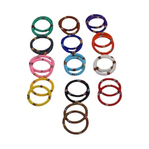 May include: A collection of beaded bracelets in various colors, including green, brown, purple, orange, white, pink, yellow, black, blue, and red. Each bracelet is adorned with a detailed pattern.