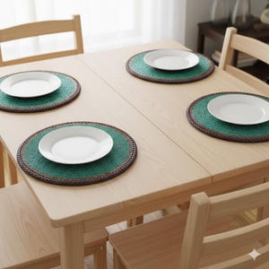 May include: A light wood dining table set for four with white plates on green and brown placemats. The table is surrounded by matching wooden chairs, creating a simple and inviting dining space.