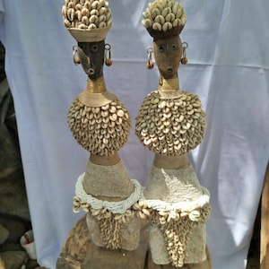 Ein Paar elegante weiße afrikanische Namich-Puppen mit Kaurimuscheln Kunstgeschenkholz-Tischplatte Wohndekor-Regalgeschäft