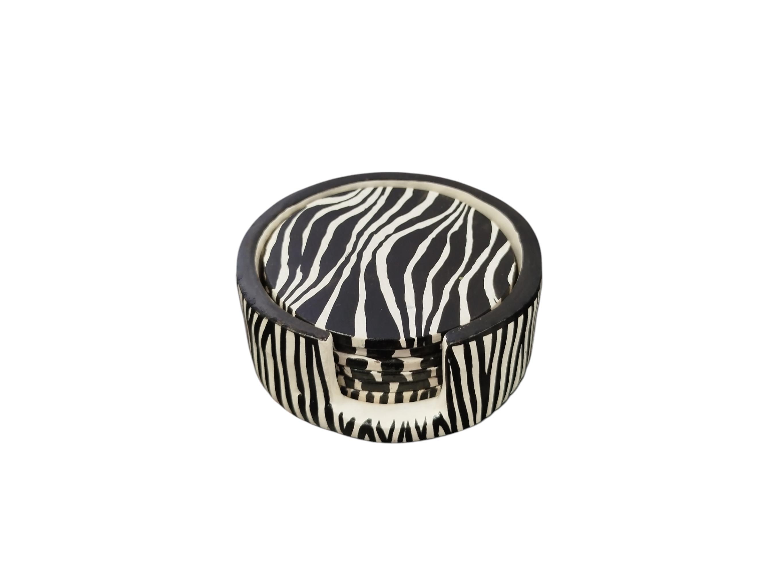 May include: A set of six round coasters with a black and white zebra stripe pattern. The coasters are stored in a matching holder, creating a cohesive and stylish tabletop accessory. The coasters are made of a durable material.