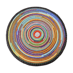 May include: A circular beaded tray with a spiral pattern. The tray is adorned with concentric rings of colourful beads in shades of red, yellow, blue, and green. The outer edge is a dark brown, braided material.