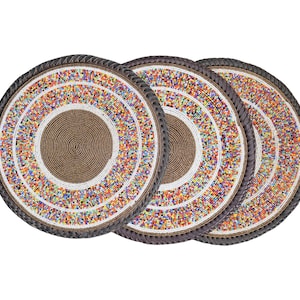 May include: Three round beaded placemats. Each mat has a central brown spiral design, encircled by rings of colourful beads. The outer edge is a dark brown, braided trim. The mats are suitable for a dining table.