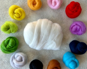 May include: A large central mound of white wool roving surrounded by twelve smaller, circular bundles of wool roving in various colors including yellow, orange, pink, red, purple, dark blue, light blue, brown, black, gray, light green, and dark green.