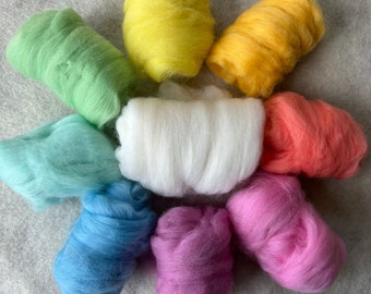 May include: A collection of nine distinct bundles of soft, fluffy wool roving arranged in a circular pattern. The colors include bright yellow, golden yellow, coral, pink, purple, blue, light blue, mint green, and a central white bundle.