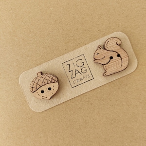 May include: Three wooden buttons featuring a squirrel, acorn, and the text "Zig Zag Crafts".
