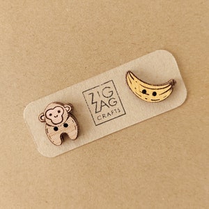 May include: A set of three wooden buttons featuring a monkey, a banana, and the text "Zig Zag Crafts".