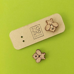 Pode incluir: Dois botões de abelha de madeira com acabamento em madeira marrom. Os botões estão em um cartão marrom com o texto "Zig Zag Crafts".