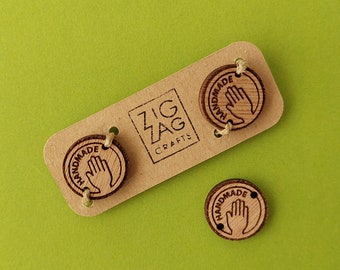 May include: Three wooden tags with the text "Handmade" and a handprint design. The tags are on a brown card with the text "Zig Zag Crafts".