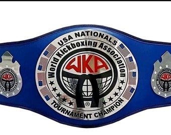 Op de afbeelding: Een blauwe kampioensgordel met zilveren accenten. De gordel heeft de tekst "USA Nationals World Kickboxing Association" en "Tournament Champion". De gordel heeft ook een zilveren logo met de tekst "WKA" in rood.