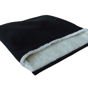 May include: Black pet bed with a white, fluffy interior. The bed has a rectangular shape and a soft, plush exterior. The interior is a contrasting white, creating a cozy space for pets to rest.