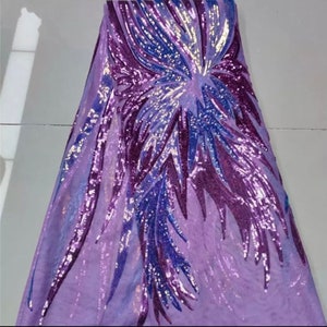 May include: Purple sequined fabric with a floral design. The sequins are iridescent and create a shimmering effect.