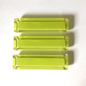 May include: Three rectangular glass containers with a bright yellow-green color. The containers are stacked on top of each other.