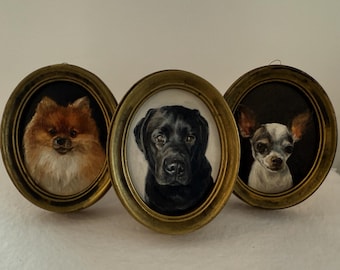 May include: Three oval-shaped wall portraits featuring detailed paintings of dogs. The left frame shows a fluffy brown Pomeranian, the center frame displays a black Labrador, and the right frame depicts a small white and grey dog with large ears.