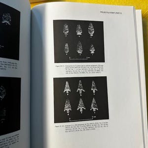May include: Open book page with images of projectile points. The page features two sets of arrowheads, each displayed against a black background. The text "PROJECTILE POINT (PART B)" is at the top. A scale of 5 cm is included.