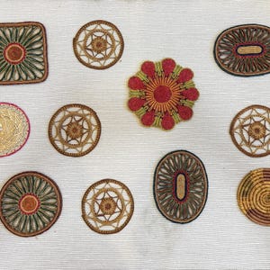 May include: A collection of 11 woven coasters in various shapes and colors, including round, oval, and square. The coasters are made of natural materials and have a rustic, handmade look.