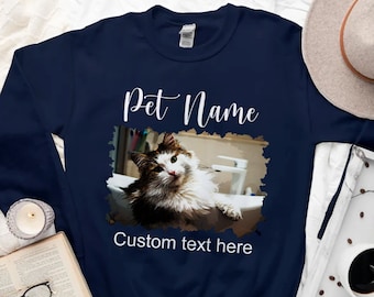 May include: Navy blue sweatshirt with a white graphic of a cat in a sink. The graphic includes the text "Pet Name" and "Custom text here".