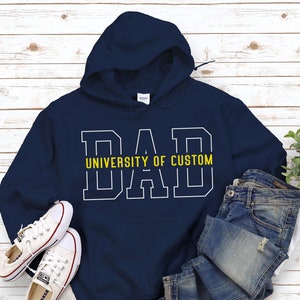 May include: Navy blue hooded sweatshirt with white text that reads "DAD UNIVERSITY OF CUSTOM" in a collegiate font.