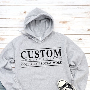 May include: Grey hooded sweatshirt with the text "CUSTOM UNIVERSITY COLLEGE OF SOCIAL WORK" printed in black.