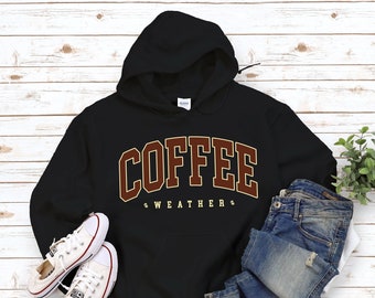 May include: Black hooded sweatshirt with the text "COFFEE WEATHER" in brown and gold letters.