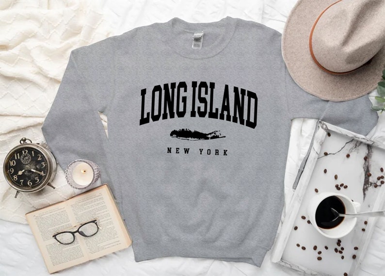 K&ouml;nnte beinhalten: Grauer Pullover mit schwarzem Text "LONG ISLAND NEW YORK" und einer Silhouette von Long Island.
