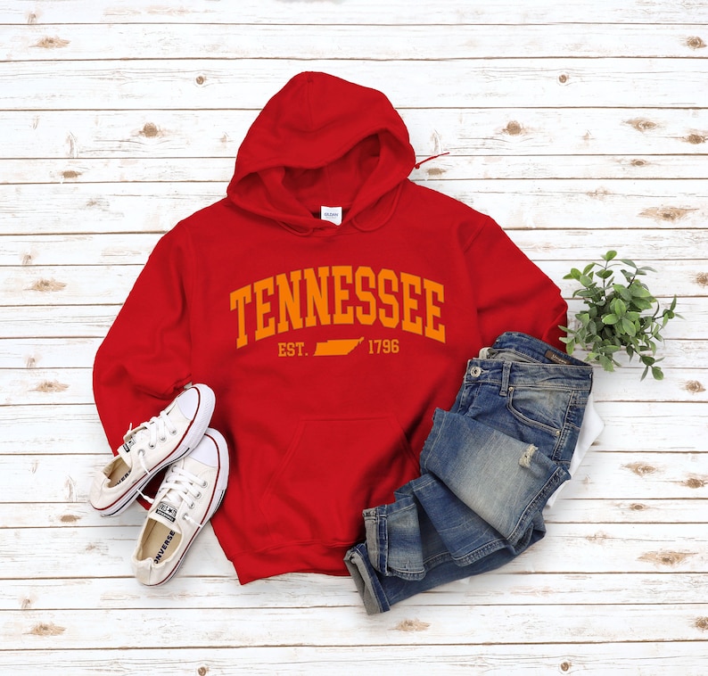May include: Red hooded sweatshirt with the text "TENNESSEE EST. 1796" in orange with an outline of the state of Tennessee in orange.