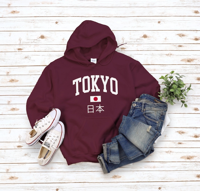 May include: Burgundy hooded sweatshirt with white text that says "TOKYO" and a Japanese flag with the text "日本" underneath.