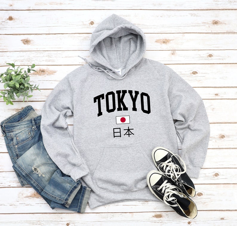 May include: Gray hooded sweatshirt with the word "TOKYO" in black lettering and a Japanese flag with the text "日本" underneath.