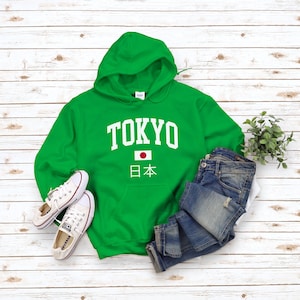 May include: Green hooded sweatshirt with white text that says "TOKYO" and a Japanese flag with the text "日本" underneath.