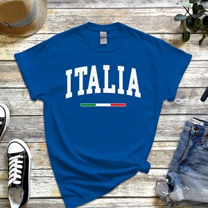 May include: A royal blue t-shirt with white text that reads "ITALIA" and a small green, white, and red stripe underneath.