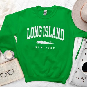 K&ouml;nnte beinhalten: Gr&uuml;ner Pullover mit wei&szlig;em Text "Long Island, New York" und einer wei&szlig;en Umrandung von Long Island.