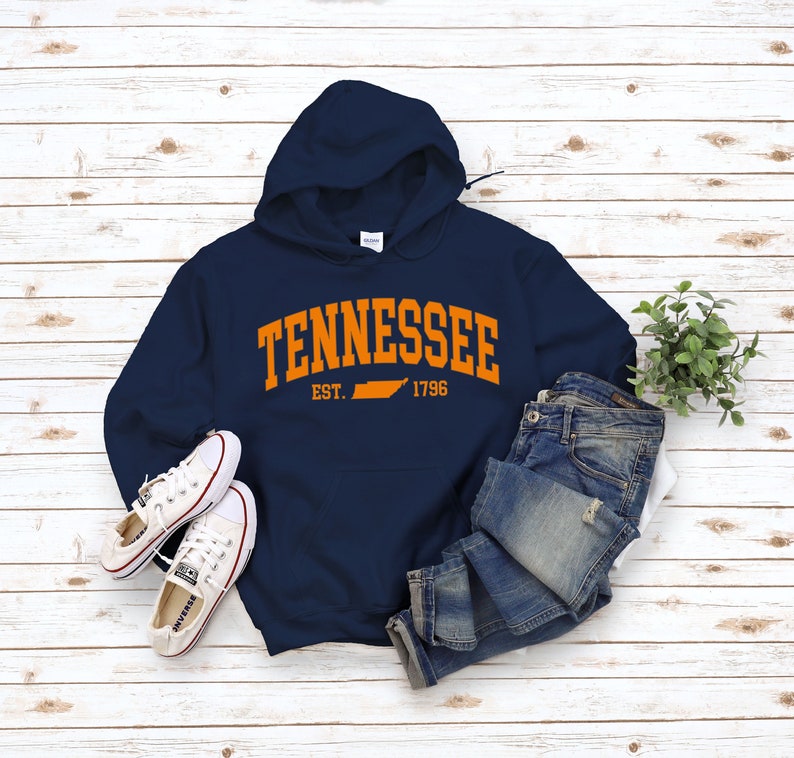 May include: A navy blue hooded sweatshirt with an orange graphic print of the state of Tennessee and the text "Tennessee Est. 1796".