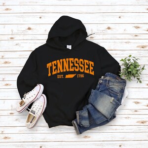 May include: Black hooded sweatshirt with an orange graphic print of the state of Tennessee and the text "Tennessee Est. 1796".