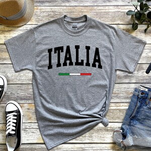 May include: Gray t-shirt with the word "ITALIA" in black block letters and a green, white, and red stripe underneath.