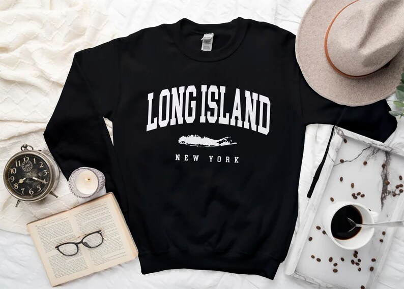 K&ouml;nnte beinhalten: Schwarzer Pullover mit wei&szlig;em Text "Long Island, New York" und einer wei&szlig;en Umrandung von Long Island.