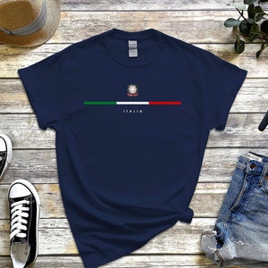 Puede incluir: Una camiseta azul marino con una franja blanca y la bandera italiana con el texto "ITALIA" debajo.