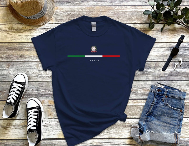 Puede incluir: Una camiseta azul marino con una franja blanca y la bandera italiana con el texto "ITALIA" debajo.