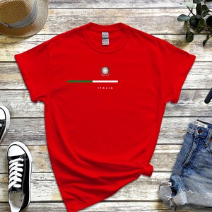 Puede incluir: Camiseta roja con una franja verde, blanca y roja a trav&eacute;s del pecho y la palabra "ITALIA" impresa debajo de la franja.